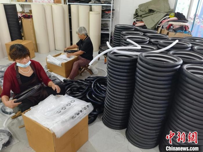 圖為村民在汽車飾品企業(yè)生產(chǎn)車間中工作?！巫雍?攝