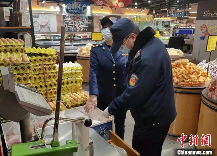 圖為疫情期間，甘肅嘉峪關(guān)市場(chǎng)監(jiān)管局工作人員檢查蔬菜市場(chǎng)?！?柴佳楠 　攝