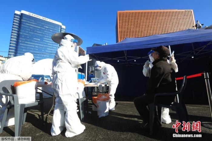 資料圖：韓國首爾，醫(yī)務(wù)人員對市民進行新冠病毒檢測。