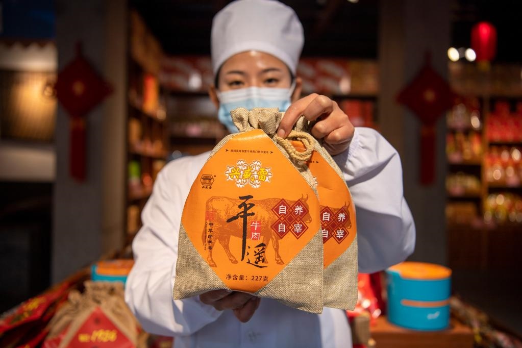 1月27日，在平遙古城南大街的一家平遙牛肉店內(nèi)，工作人員展示一款牛肉產(chǎn)品。新華社記者 楊晨光 攝