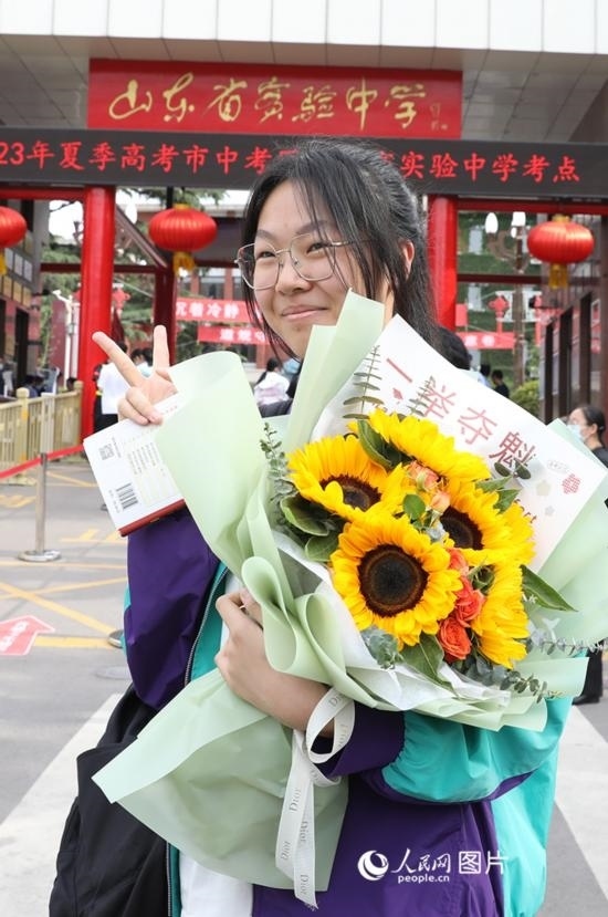 6月7日高考首日，山東67萬(wàn)考生走進(jìn)考場(chǎng)，拼搏逐夢(mèng)。在山東省實(shí)驗(yàn)中學(xué)考點(diǎn)，考生進(jìn)考場(chǎng)前手捧向日葵花拍照留念，寓意“一舉奪魁”。人民網(wǎng)記者 劉祺攝