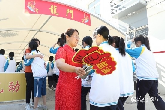 6月7日一早，雄安新區(qū)安新中學(xué)老師在給同學(xué)們加油鼓勁兒。人民網(wǎng) 李兆民攝