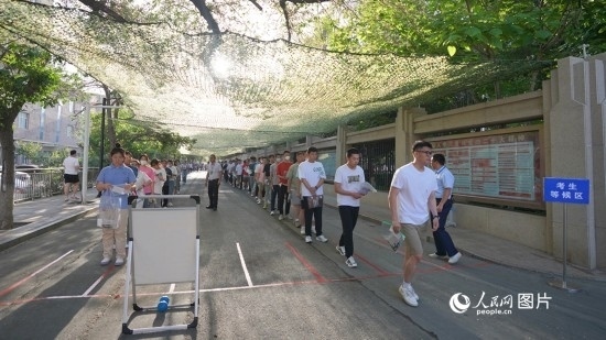 6月7日，烏魯木齊市第七十中學(xué)門口，考生們有序進(jìn)入考場(chǎng)。人民網(wǎng) 李欣洋攝