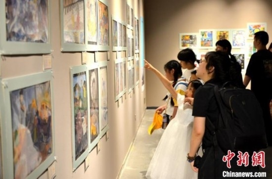 圖為家長帶著孩子參觀展覽。呂明 攝