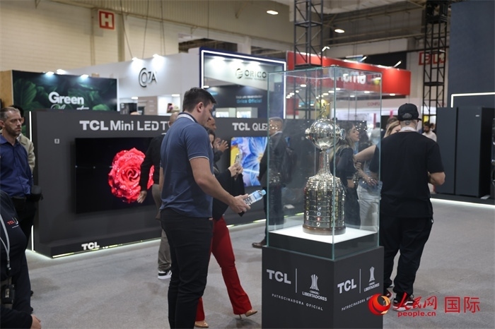 參觀者在TCL展臺(tái)前觀看南美解放者杯獎(jiǎng)杯，據(jù)介紹，TCL是南美解放者杯（2023—2026賽季）全球官方合作伙伴。（人民網(wǎng)記者 時(shí)元皓攝）