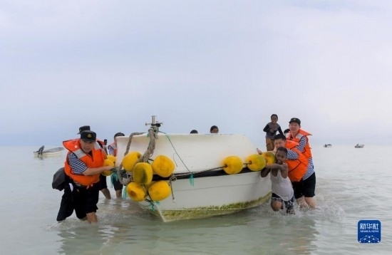 7月21日，中國海軍“和平方舟”號醫(yī)院船醫(yī)護(hù)人員涉水登島，前往基里巴斯一診療點(diǎn)。新華社記者 黎云 攝