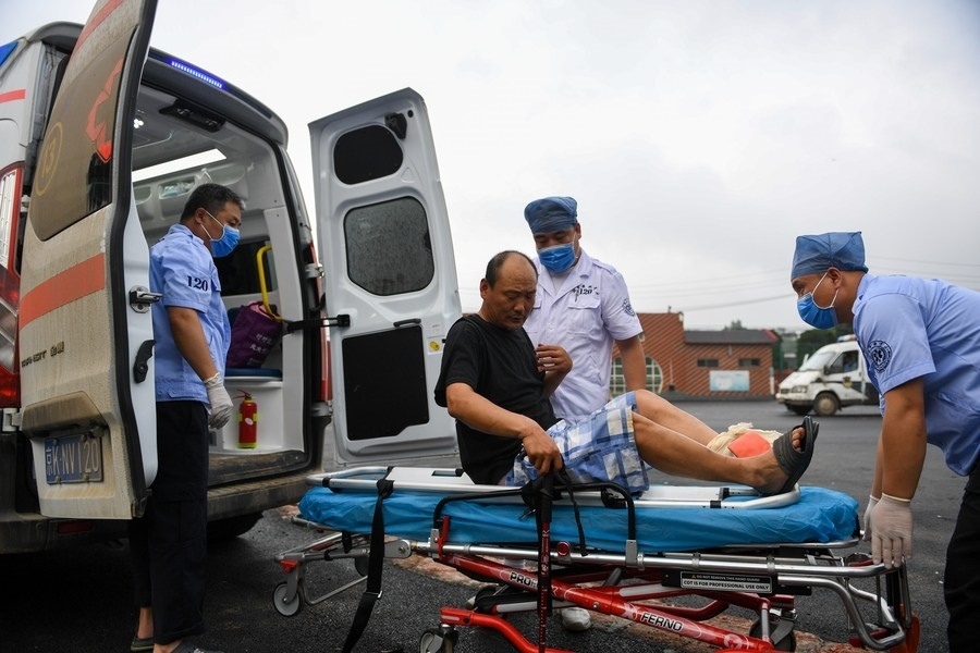 8月1日，在北京市門頭溝區(qū)妙峰山鎮(zhèn)妙峰山民族學校臨時安置點，北京急救中心工作人員在轉(zhuǎn)運一名受傷村民。新華社記者 鞠煥宗 攝