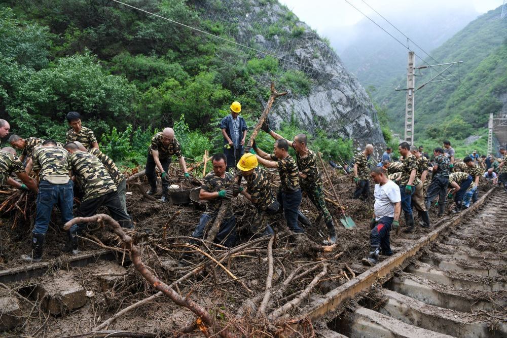 8月1日，在北京市門頭溝區(qū)水峪嘴村附近一段被阻斷的鐵路線上，中鐵六局工作人員在清理軌道上的雜物，全力恢復(fù)交通。新華社記者 鞠煥宗 攝