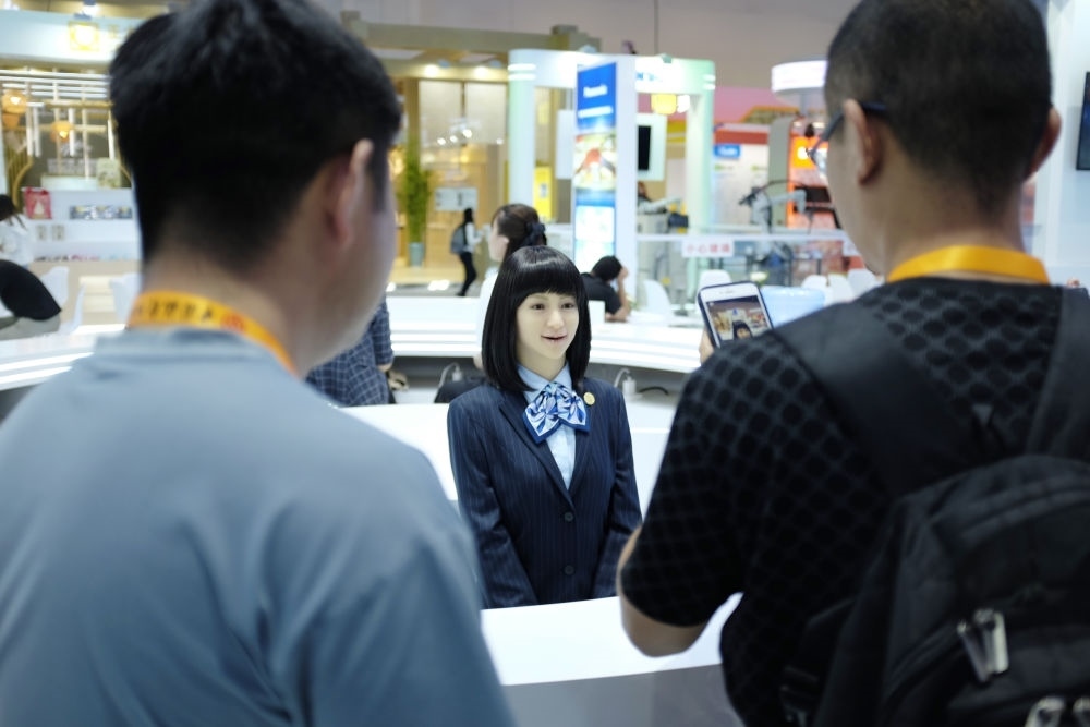 9月1日，媒體記者在國家會議中心與服務(wù)機器人互動。新華社記者 劉夢琪 攝