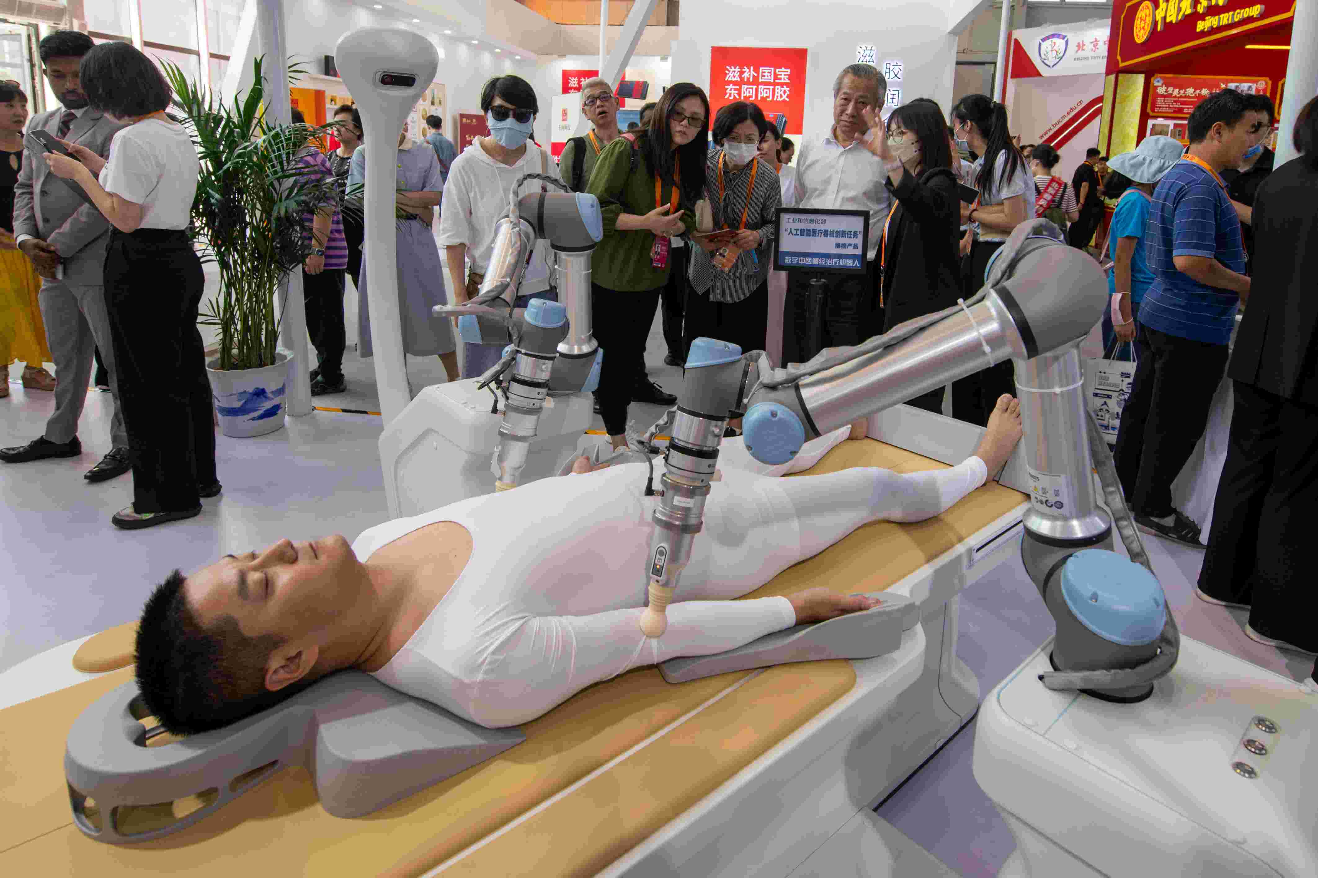 在位于首鋼園的健康衛(wèi)生服務(wù)展區(qū)，觀眾正在參觀數(shù)字中醫(yī)循經(jīng)治療機器人。人民網(wǎng)記者 翁奇羽攝