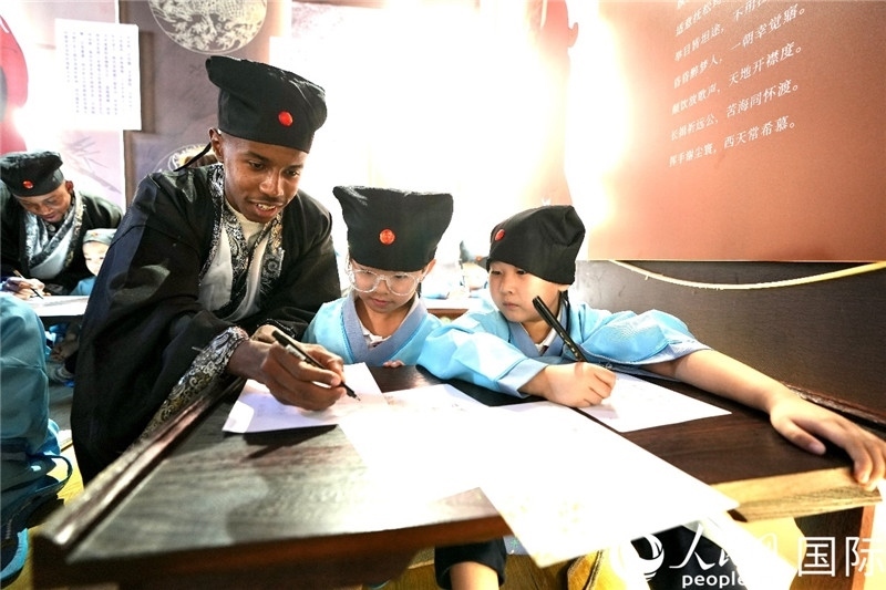 圖為選手與同學(xué)們一起寫(xiě)書(shū)法。人民網(wǎng) 盧鵬宇攝