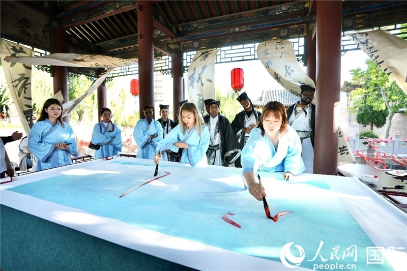 選手們提筆書(shū)寫(xiě)“家園”二字。人民網(wǎng) 盧鵬宇攝