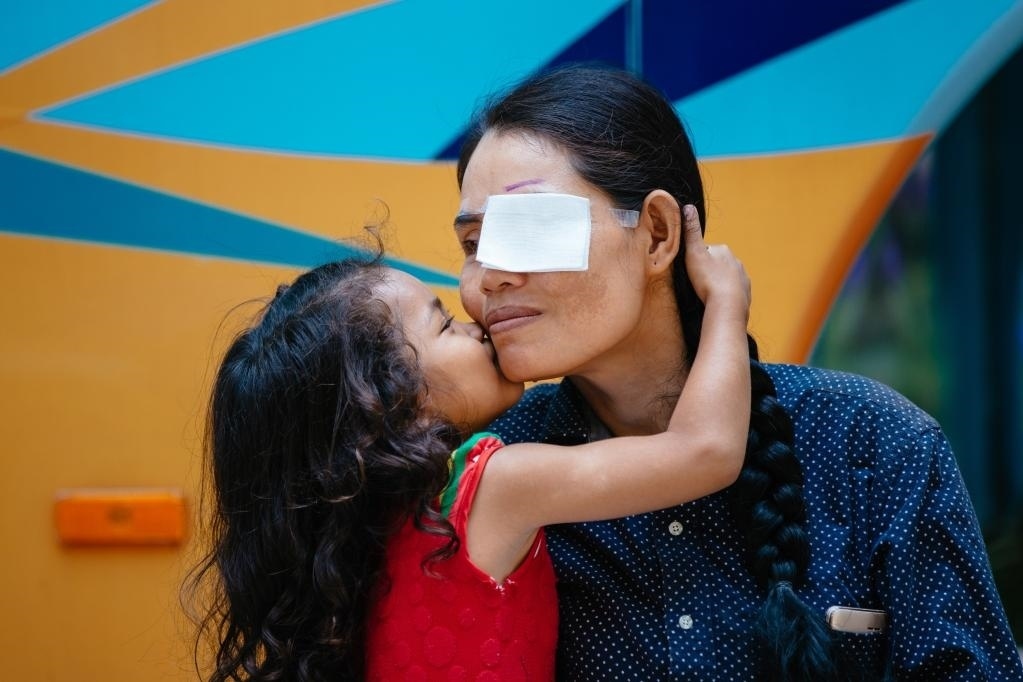 2019年3月15日，在柬埔寨磅湛省醫(yī)院，即將接受白內(nèi)障手術(shù)的患者孫美樂接受女兒的親吻祝福。在接受了中國醫(yī)療隊的白內(nèi)障義診手術(shù)后，她的視力逐步恢復，生活有了新的光明和希望。