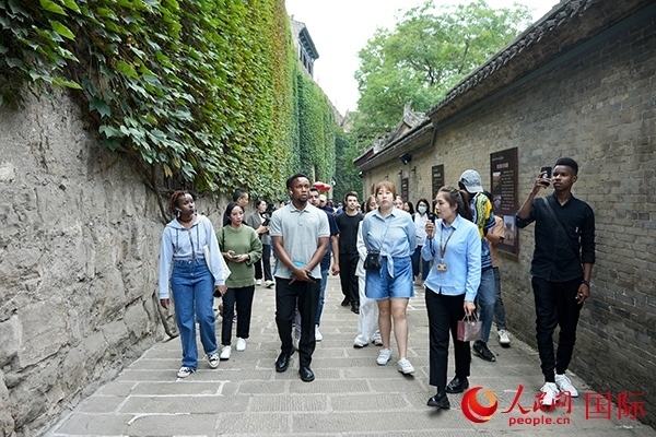 選手們認(rèn)真聆聽導(dǎo)游講解。人民網(wǎng) 盧鵬宇攝