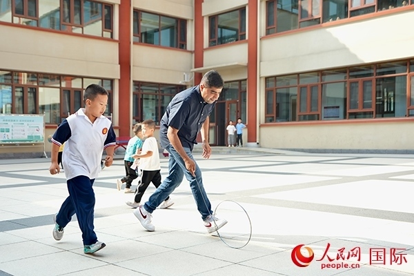 來(lái)自巴基斯坦的沙杰在滾鐵環(huán)。人民網(wǎng) 盧鵬宇攝