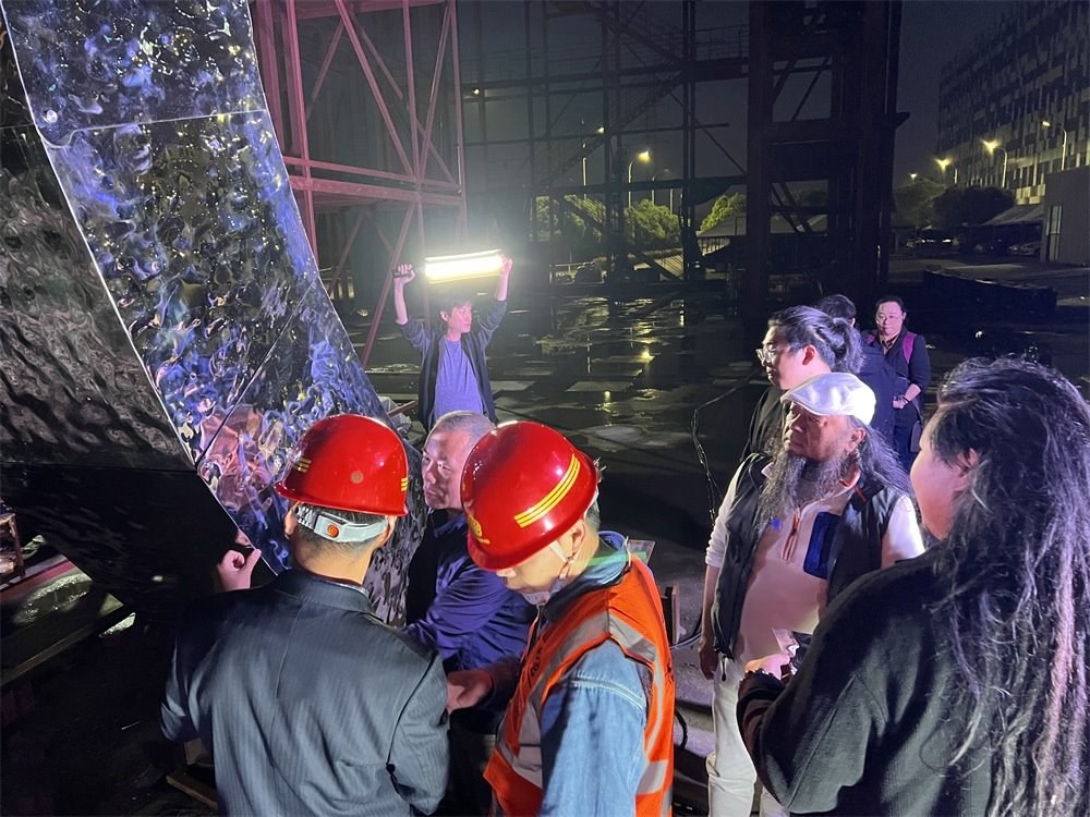 林崗（右二）和團(tuán)隊(duì)查看主火炬制作進(jìn)度。受訪者供圖