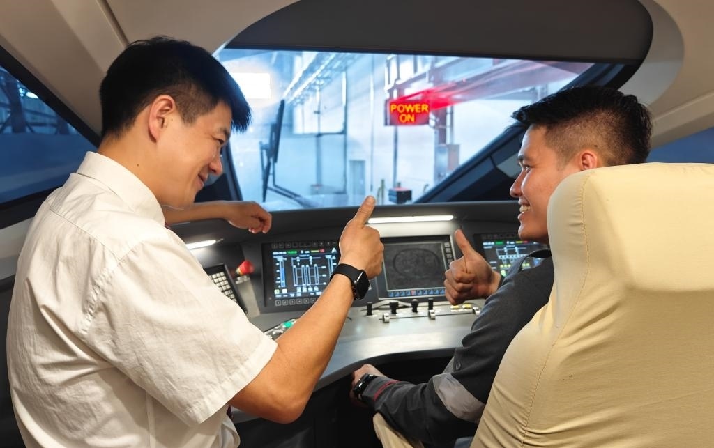 8月25日，在印度尼西亞萬(wàn)隆的雅萬(wàn)高鐵德卡魯爾動(dòng)車(chē)所內(nèi)，中國(guó)師傅穆振（左）在向印尼火車(chē)司機(jī)塞蒂亞萬(wàn)講解動(dòng)車(chē)組出庫(kù)前的上電作業(yè)。