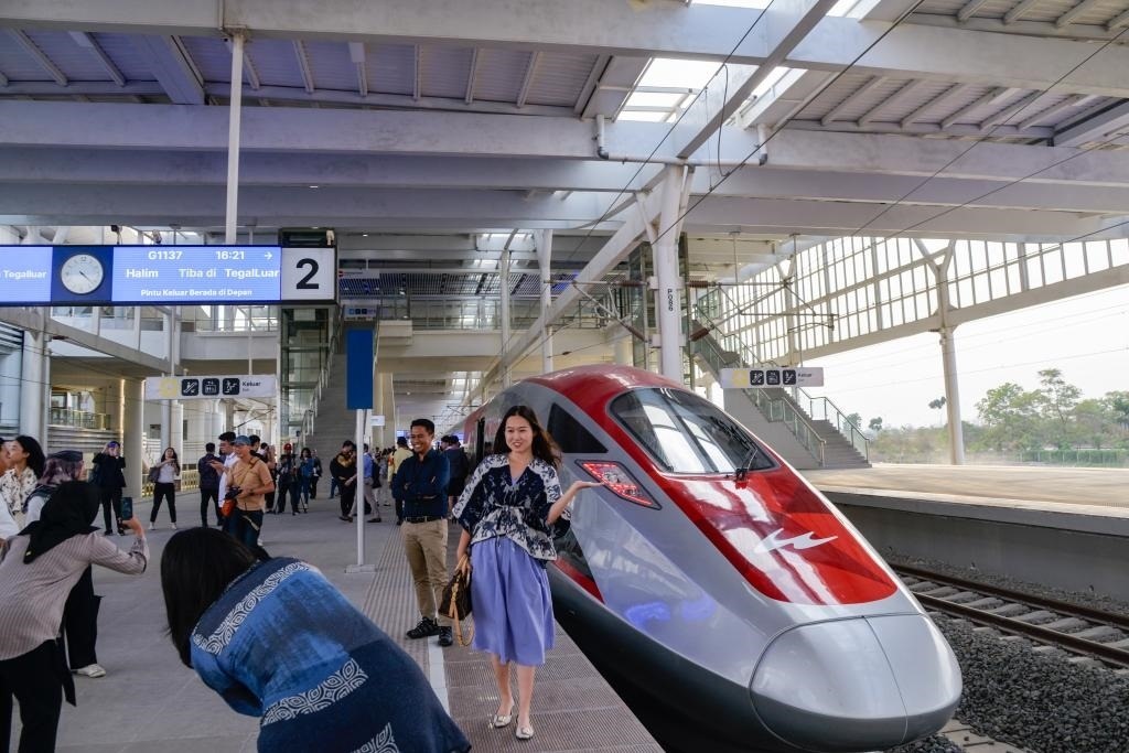 10月17日，在印度尼西亞萬(wàn)隆德卡魯爾站，乘客在站臺(tái)上和雅萬(wàn)高鐵高速動(dòng)車(chē)組列車(chē)合影。