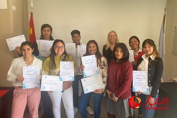 社區(qū)工作專(zhuān)家莫伊拉（后排右二）向“中文工坊”第二期培訓(xùn)班部分結(jié)業(yè)學(xué)員頒發(fā)由薩爾塔省教育部簽發(fā)的結(jié)業(yè)證書(shū)。人民網(wǎng)記者 吳思萱攝