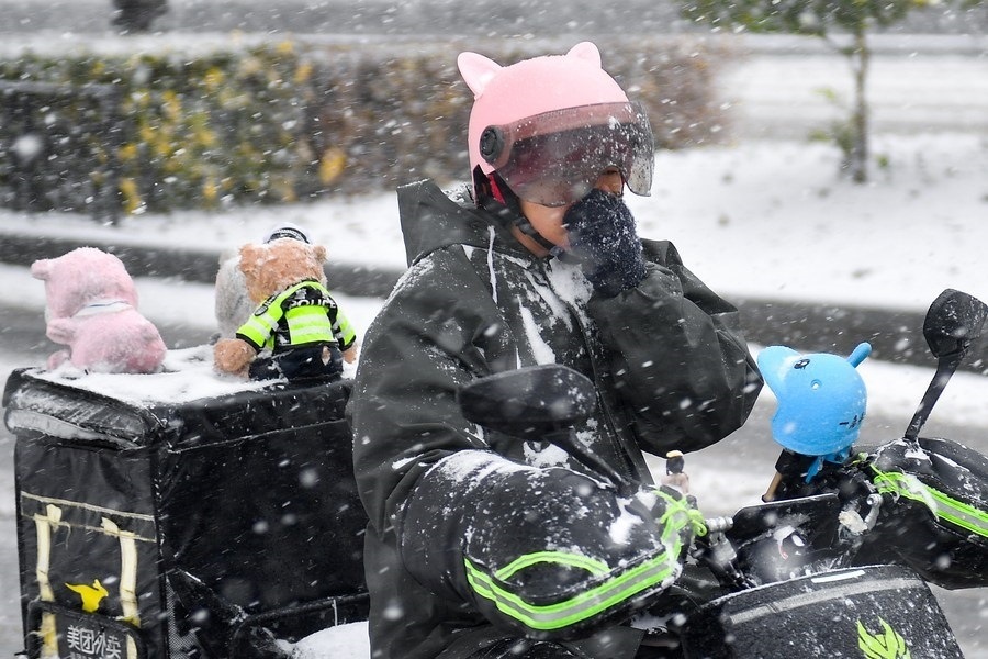 11月6日，在長春市街頭，一名外賣員在雪中騎行。新華社記者 許暢 攝