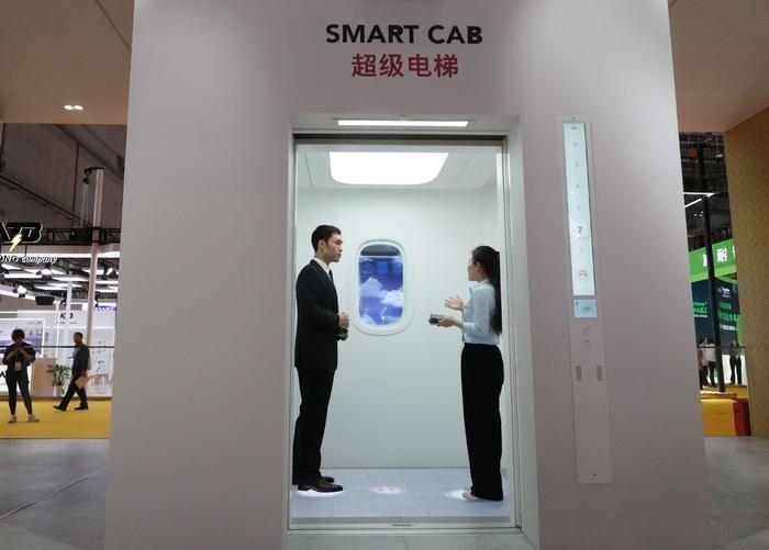 11月5日，工作人員（右）在第六屆進(jìn)博會(huì)上向參觀者介紹奧的斯公司全新推出的超級(jí)電梯。