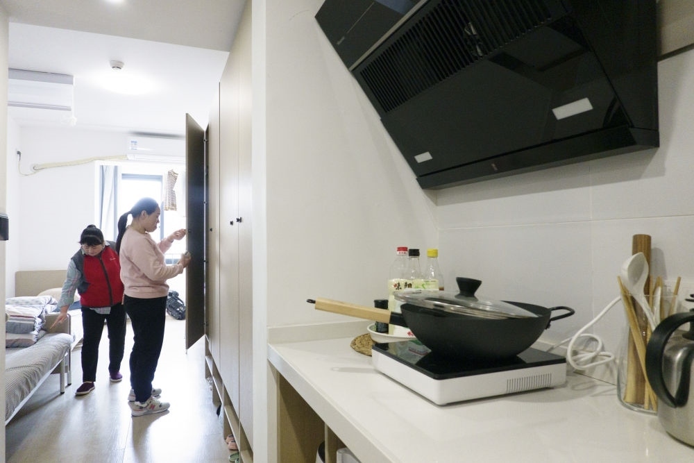 住戶在閔行區(qū)新時代城市建設者管理者之家收拾房間。