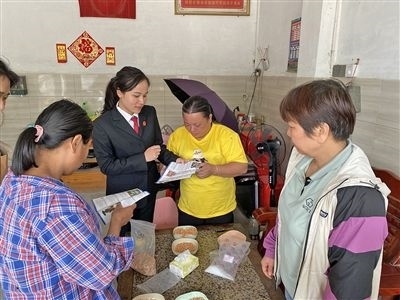  圖⑤：龍圩區(qū)法院法官到群眾家中開展法治宣傳。資料圖片