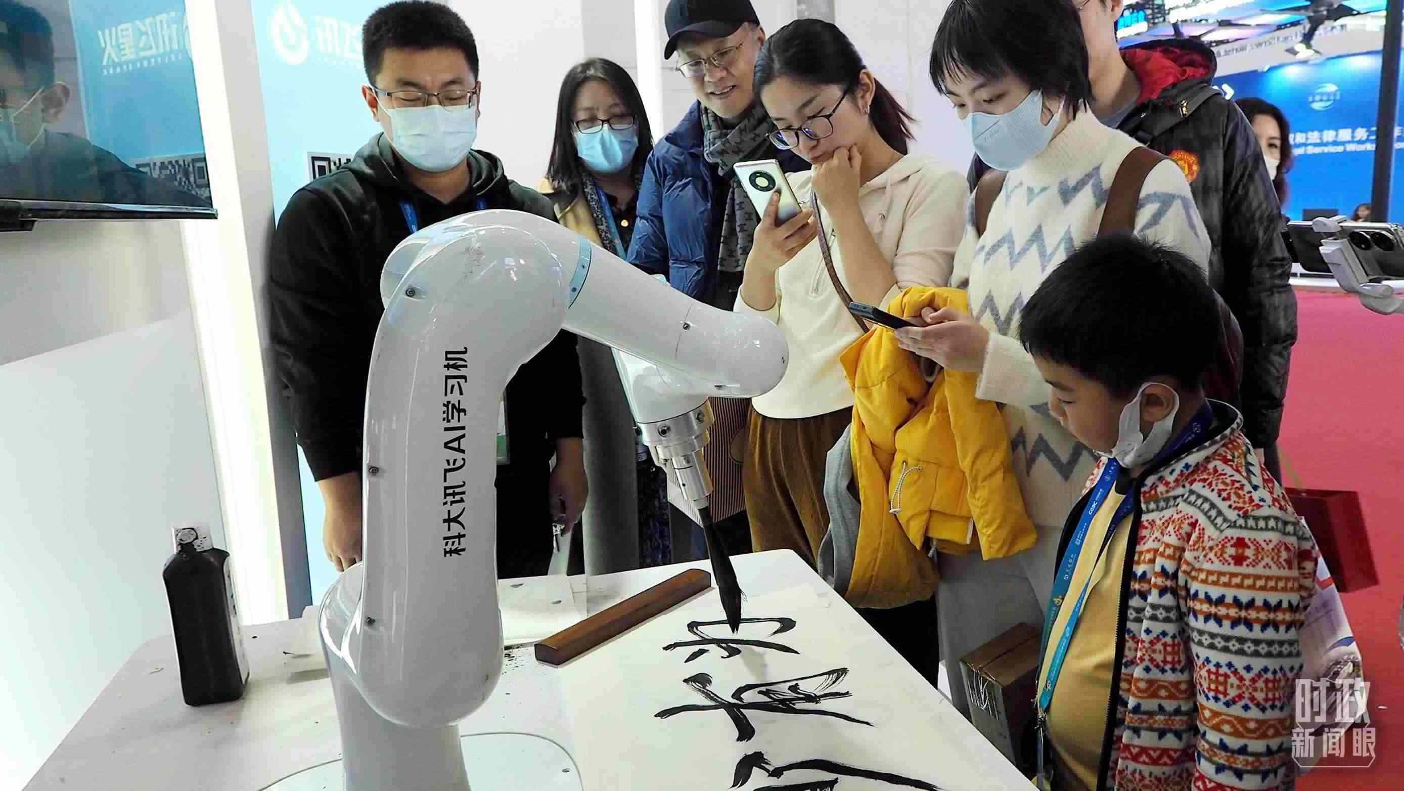 △觀眾在首屆鏈博會(huì)上體驗(yàn)AI書(shū)法機(jī)器人。