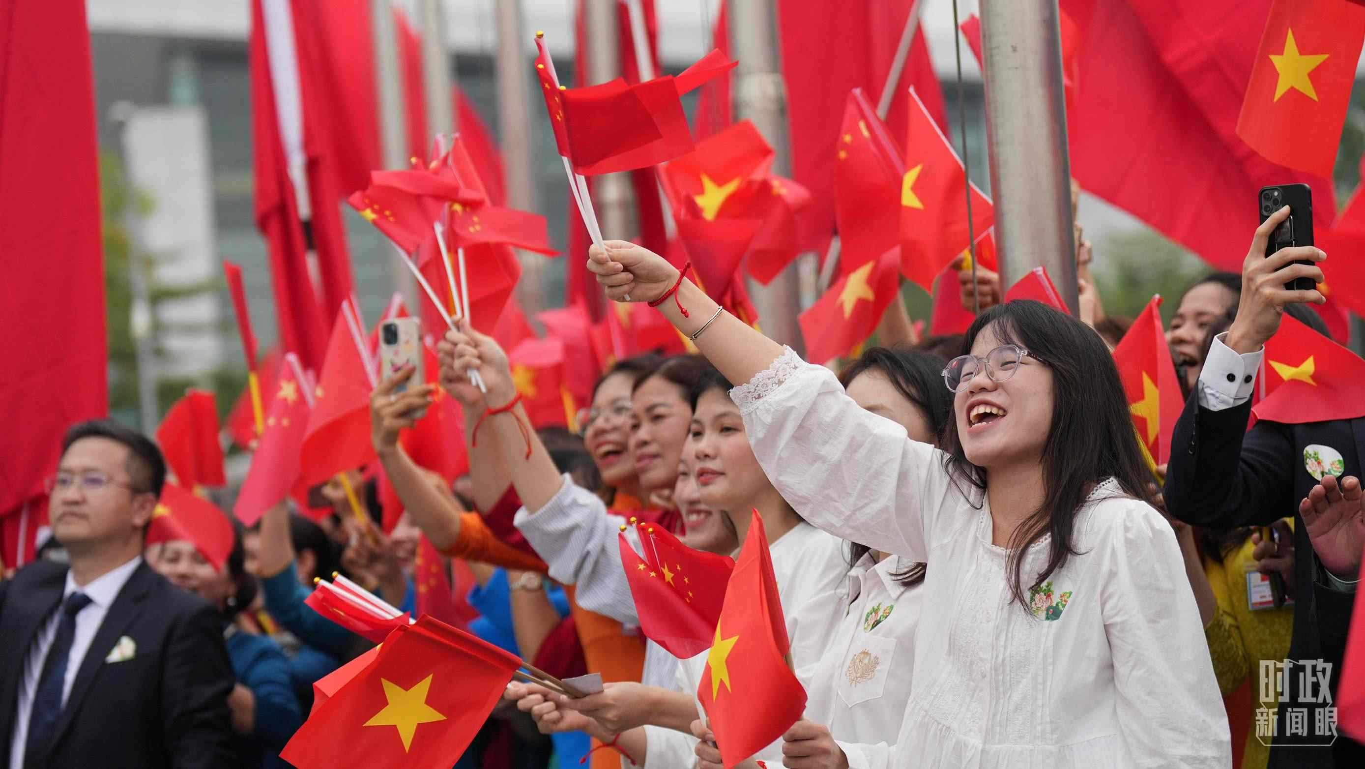 △人們揮舞兩國旗幟歡迎習(xí)近平訪越。（總臺國廣記者李晉拍攝）