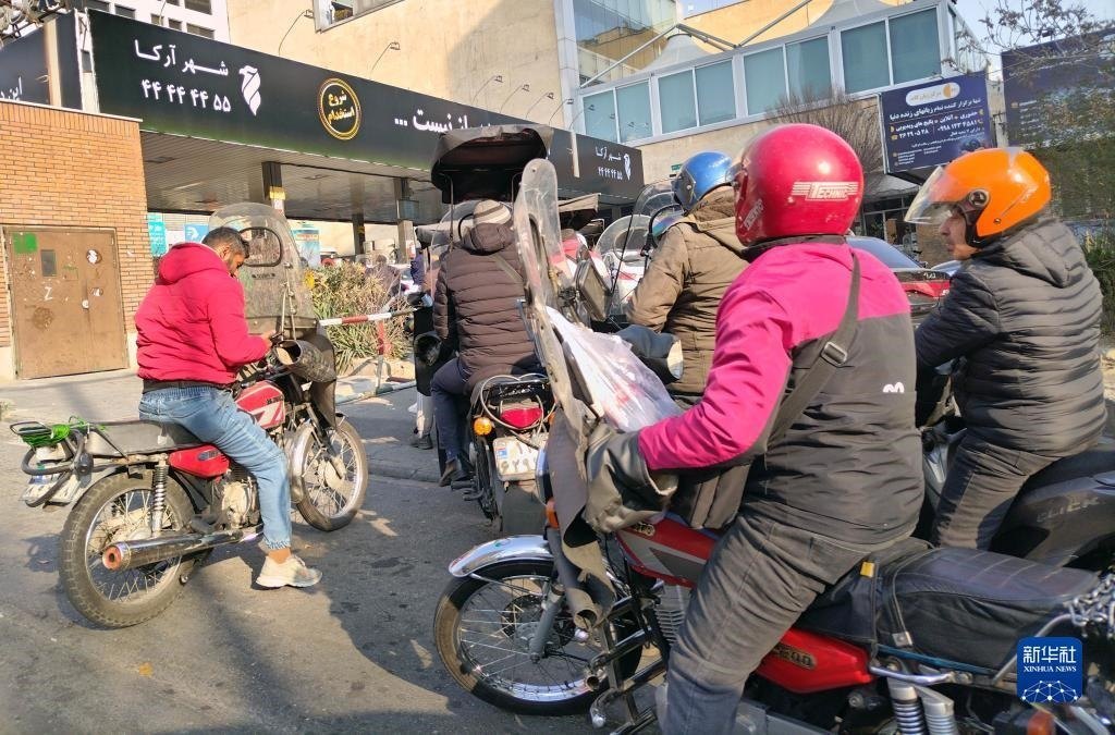 12月18日，摩托車在伊朗首都德黑蘭的一家加油站外等待加油。新華社記者 沙達(dá)提 攝