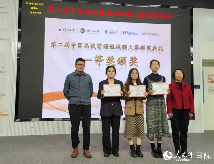 澳門大學(xué)中葡雙語教學(xué)暨培訓(xùn)中心主任姚京明（左一）和中國傳媒大學(xué)外國語言文化學(xué)院院長文春英（右一）為一等獎(jiǎng)獲得者頒獎(jiǎng)。人民網(wǎng)記者 魯揚(yáng)攝