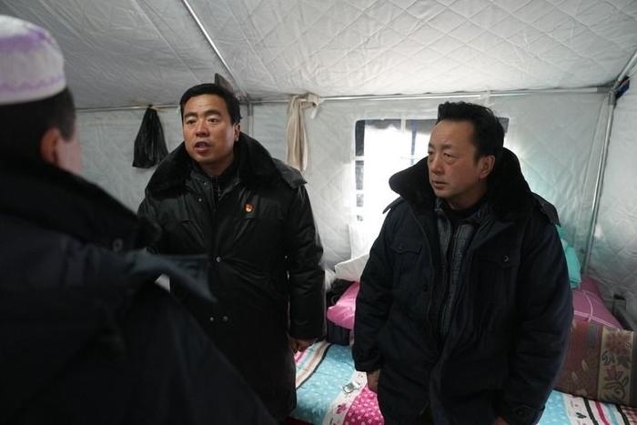 2023年12月22日，積石山縣大河家鎮(zhèn)大河村黨支部書記馬成忠（右二）在帳篷里和受災群眾交流。新華社記者 陳斌 攝