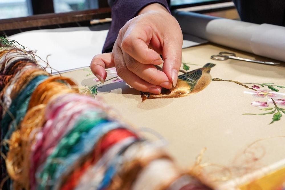 △2023年7月6日，盧建英在江蘇蘇州平江路的工作室內(nèi)刺繡。