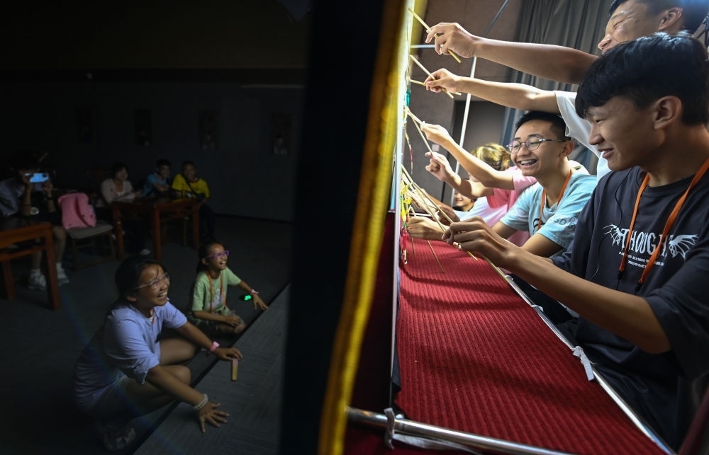 2023年8月8日，進行暑期研學(xué)的學(xué)生在位于陜西省西安市的中國秦腔藝術(shù)博物館體驗皮影戲演出。新華社記者 鄒競一 攝