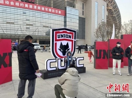 球迷們與隊(duì)徽合影。記者 卞立群 攝