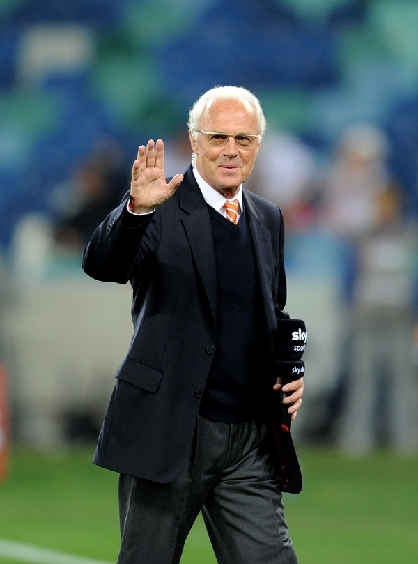 這是2010年7月7日，在南非德班舉行的2010年足球世界杯德國隊對陣西班牙隊的半決賽前，貝肯鮑爾接受電視臺采訪時和友人打招呼。新華社記者 王毓國 攝