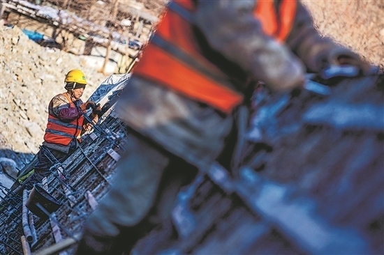 1月3日，房山區(qū)，工人正在雙泉河修筑堤壩。