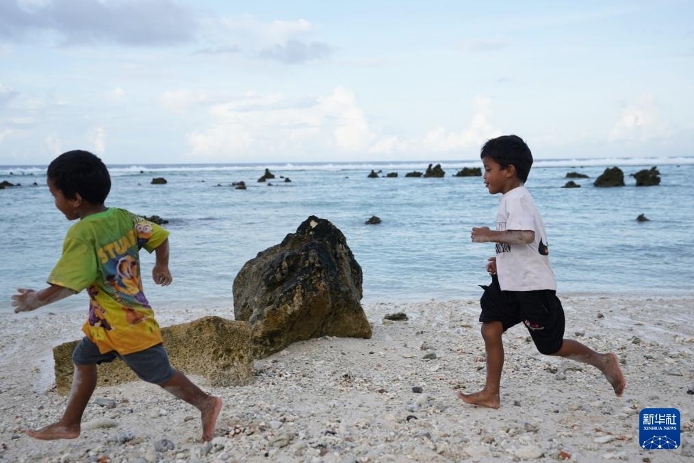 1月20日，兒童在瑙魯海邊嬉戲。新華社記者 王申 攝