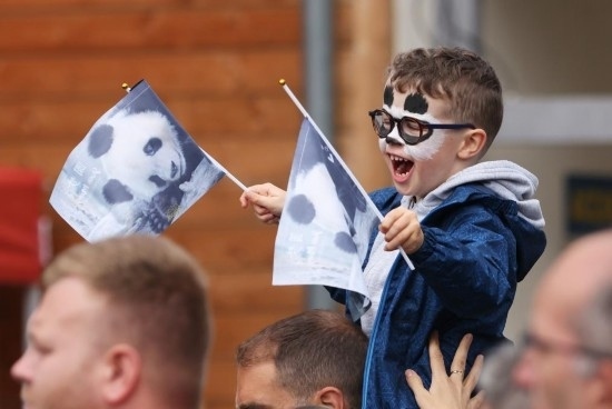  2023年7月26日，在法國圣艾尼昂市博瓦勒野生動(dòng)物園外，一名兒童等待送別熊貓“圓夢”。新華社記者 高靜 攝