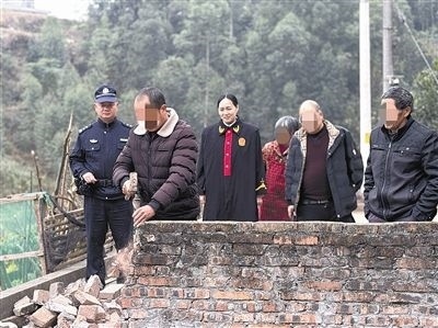  圖③：庭審結(jié)束后，在法官的見(jiàn)證下，陳某在院壩邊重新開(kāi)鑿一條通道。