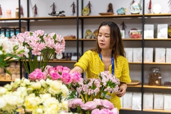 2023年7月1日，在位于湖南省長沙市的湖南高橋大市場，中非經(jīng)貿(mào)博覽會常設(shè)展館展區(qū)肯尼亞館工作人員在整理產(chǎn)自非洲的鮮花。新華社記者 陳思汗 攝