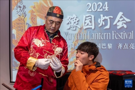 1月28日，在上海豫園舉行的民俗活動上，美國馬斯卡廷中學(xué)學(xué)生在非遺傳承人的指導(dǎo)下吹糖偶。 新華社記者 王翔 攝