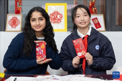 1月28日，美國馬斯卡廷中學(xué)學(xué)生（左）和復(fù)旦大學(xué)第二附屬學(xué)校學(xué)生展示互相送出的寫有寄語祝福的紅包。 新華社記者 王翔 攝