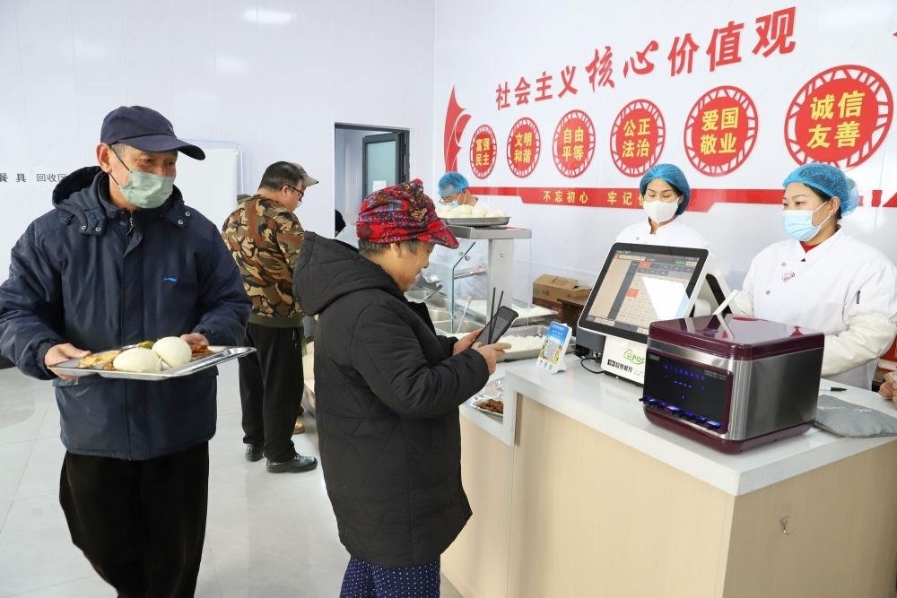 △2024年2月1日，市民在河北涿州市雙塔街道永濟(jì)秀園小區(qū)便民食堂內(nèi)購買午餐。