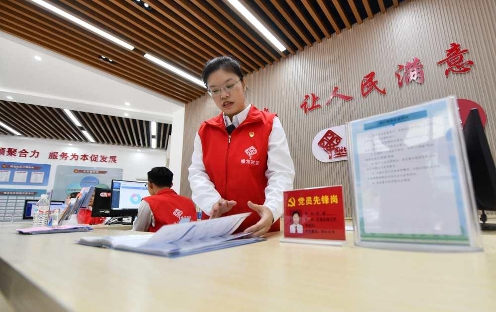 △2023年12月14日，廣西南寧市蟠龍社區(qū)，工作人員在為居民服務(wù)。