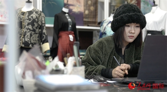 1月23日，在山東省菏澤市曹縣有愛云倉直播基地，張子晨正在設(shè)計漢服。 人民網(wǎng)記者 袁蒙攝