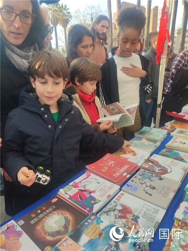 印刷精美的中國(guó)傳統(tǒng)文化叢書(shū)吸引了小游客的注意。人民網(wǎng)記者鄭彬攝