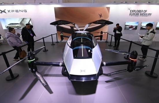 2023年12月1日，在鏈博會(huì)智能汽車鏈展區(qū)小鵬汽車展臺，參觀者觀看一臺智能飛行器。新華社記者蔡湘鑫攝