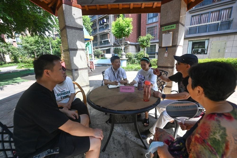 △2023年7月21日，在位于浙江杭州臨安區(qū)錦南街道水岸陽光小區(qū)的陽光議事廳，街道干部在聽取居民們反映的問題及意見。