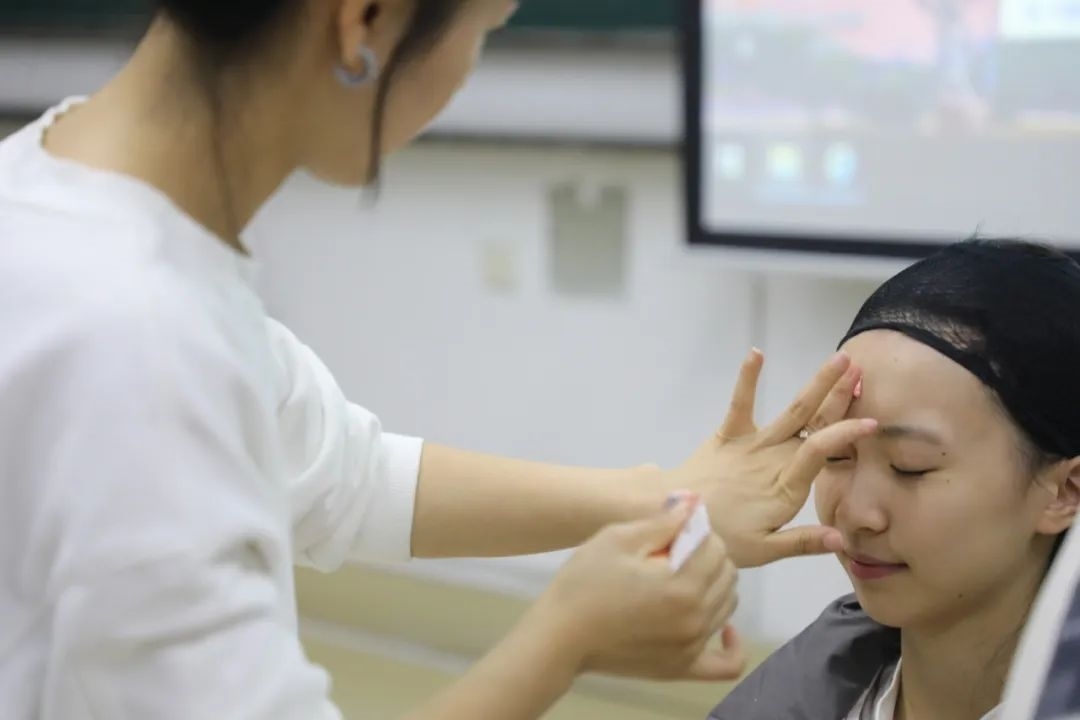 課堂上，一名學(xué)生在體驗(yàn)上戲妝。學(xué)校供圖